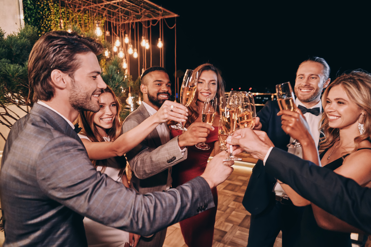 Group of beautiful people in formalwear toasting with champagne and smiling